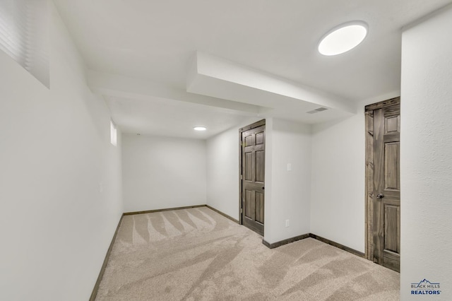 finished basement with visible vents, baseboards, and carpet