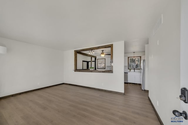 interior space featuring visible vents, ceiling fan, baseboards, and wood finished floors