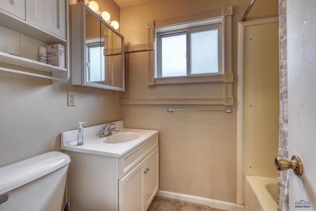 full bathroom with toilet, vanity, and baseboards