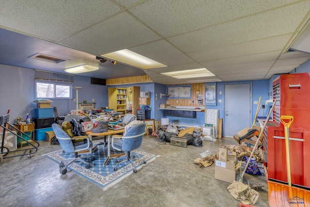 interior space featuring a paneled ceiling and concrete floors