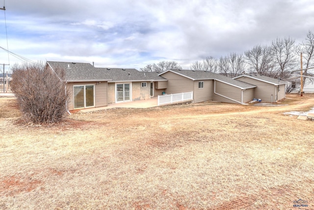 back of property with a patio and a shingled roof