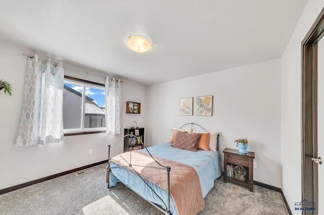 carpeted bedroom featuring visible vents and baseboards