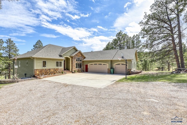 view of front of property featuring concrete driveway, an attached garage, stone siding, and roof with shingles