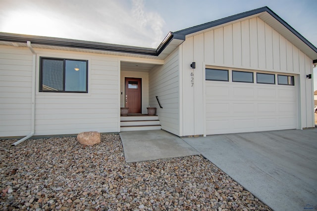 single story home with concrete driveway, an attached garage, and board and batten siding