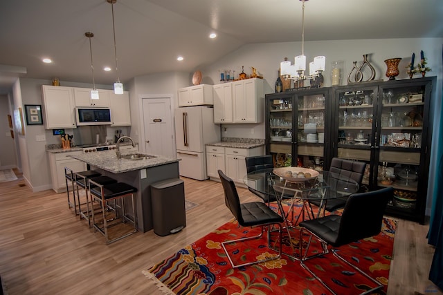 dining area featuring recessed lighting, lofted ceiling, a notable chandelier, and light wood finished floors