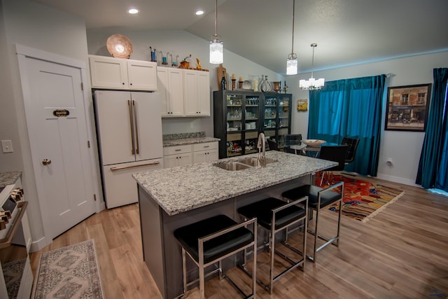 kitchen featuring a sink, freestanding refrigerator, light wood-style floors, white cabinets, and range