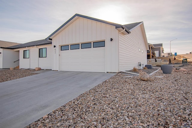 view of home's exterior with a garage, board and batten siding, and driveway