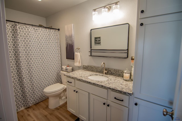 bathroom with curtained shower, toilet, vanity, and wood finished floors