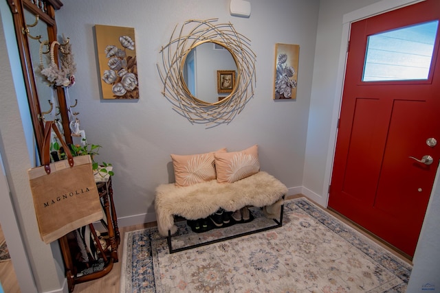 foyer featuring baseboards and wood finished floors