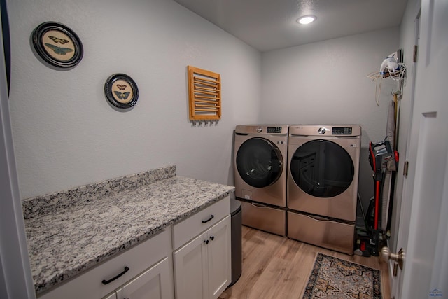 laundry area with light wood-style floors and washing machine and clothes dryer