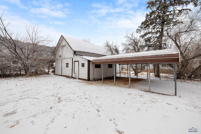 snow covered structure featuring a carport