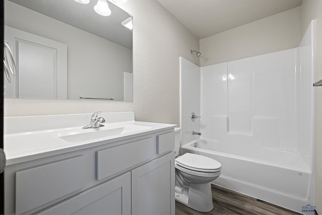 full bath with bathing tub / shower combination, toilet, wood finished floors, and vanity