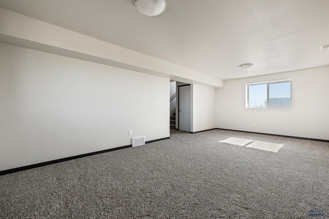 spare room with visible vents, baseboards, carpet, and a textured ceiling