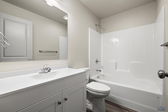 full bathroom featuring toilet, shower / washtub combination, wood finished floors, and vanity