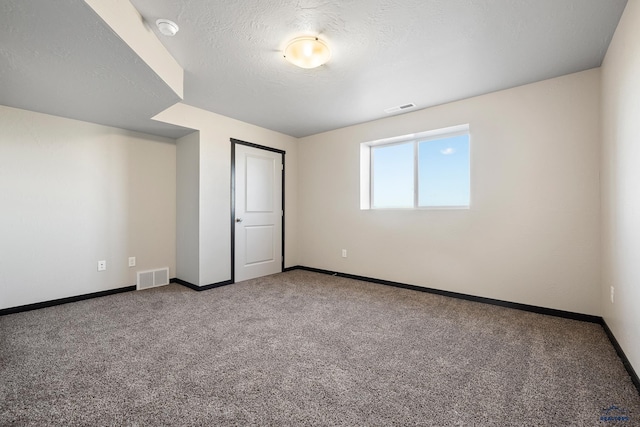 unfurnished bedroom featuring visible vents, carpet flooring, a textured ceiling, and baseboards