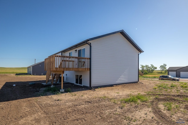 view of side of home featuring stairway and a deck