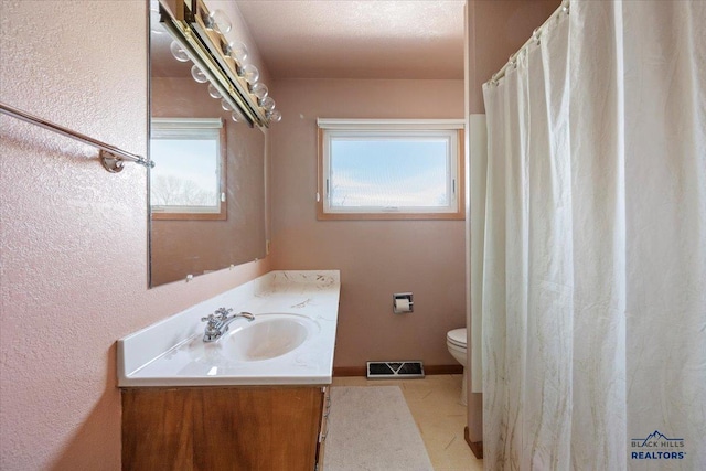 bathroom featuring visible vents, toilet, vanity, a shower with shower curtain, and a textured ceiling