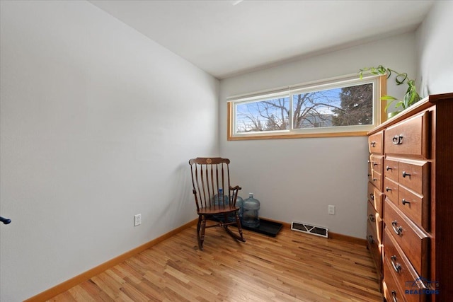 sitting room featuring light wood-style flooring, baseboards, and visible vents