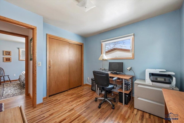 office space with light wood-style flooring and baseboards