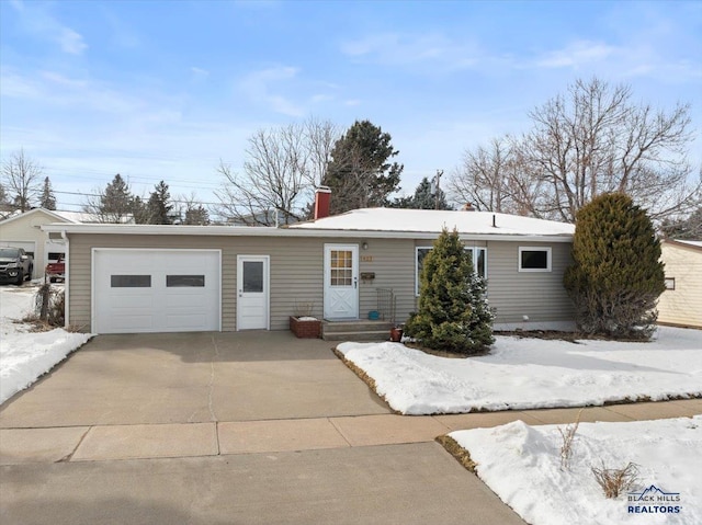 ranch-style house with concrete driveway, a garage, and a chimney