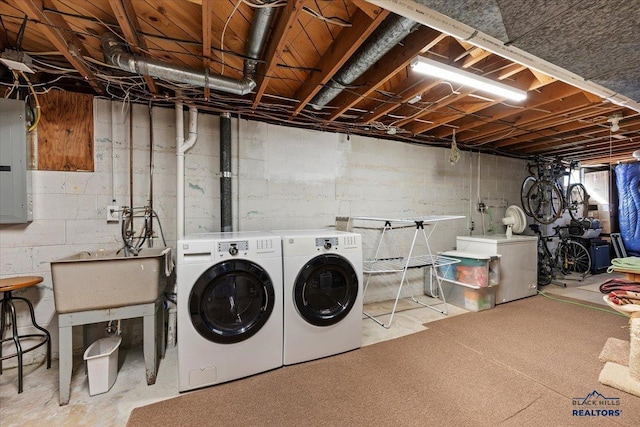 washroom featuring electric panel, laundry area, independent washer and dryer, and a sink