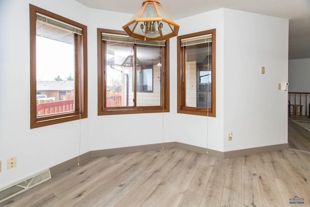 unfurnished room featuring visible vents, baseboards, and light wood-style flooring