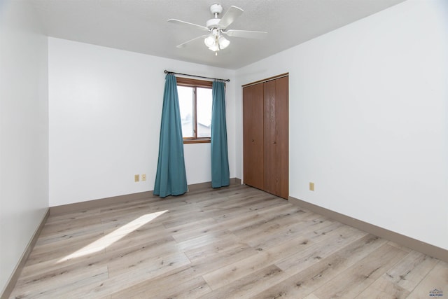 empty room featuring light wood-style flooring, baseboards, and ceiling fan