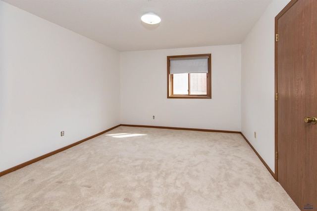 spare room with baseboards and carpet floors