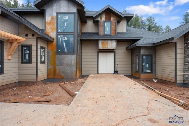 view of front of home with a shingled roof