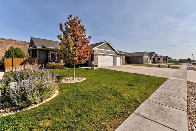 ranch-style home with a front lawn, driveway, stone siding, fence, and a garage