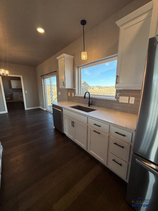 kitchen with dishwashing machine, tasteful backsplash, freestanding refrigerator, and a sink