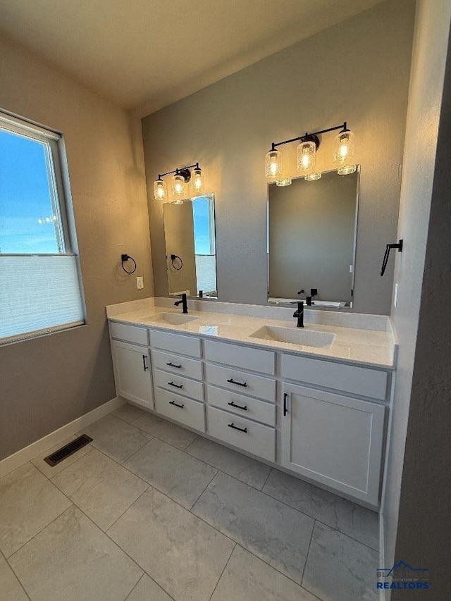 full bathroom featuring double vanity, visible vents, marble finish floor, and a sink