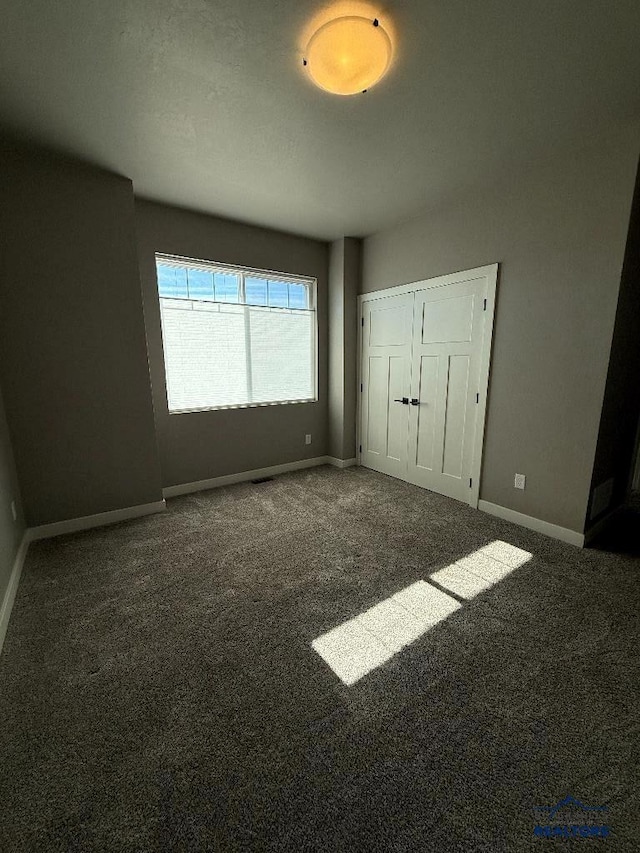 unfurnished bedroom with a closet, baseboards, and carpet floors