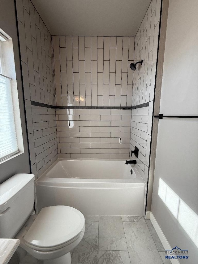 full bath featuring marble finish floor, tub / shower combination, toilet, and baseboards