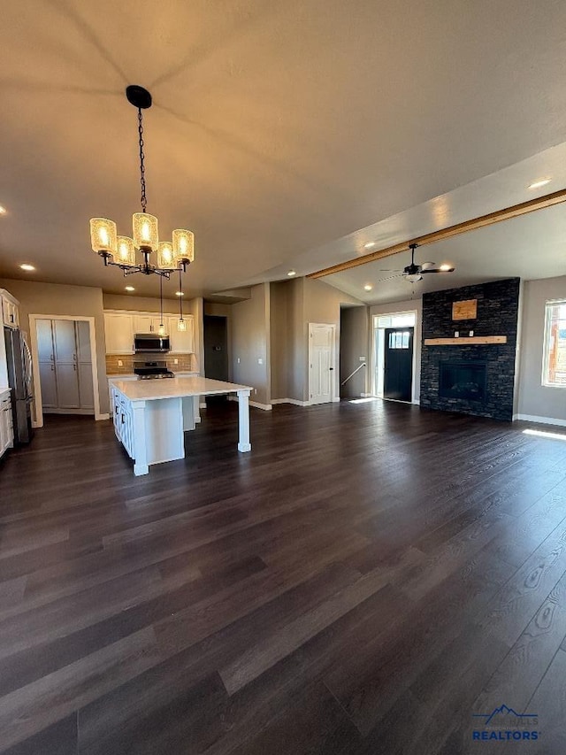 kitchen with a breakfast bar, freestanding refrigerator, light countertops, white cabinetry, and stainless steel microwave