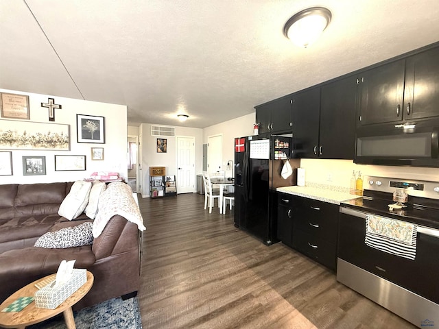 kitchen with dark wood finished floors, black appliances, open floor plan, and dark cabinets