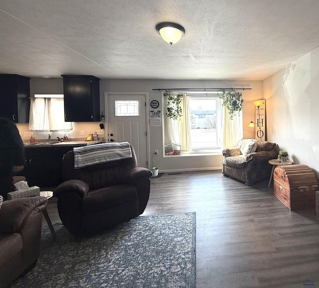 living room with plenty of natural light, dark wood-type flooring, and a textured ceiling