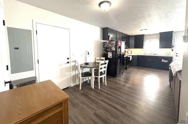 dining area featuring electric panel, dark wood finished floors, and a textured ceiling