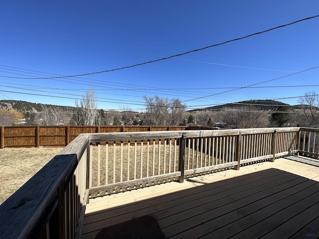 wooden deck featuring a mountain view and a fenced backyard