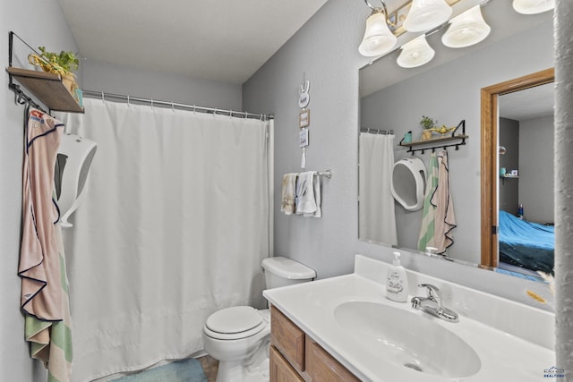 bathroom featuring toilet, vanity, and a shower with shower curtain