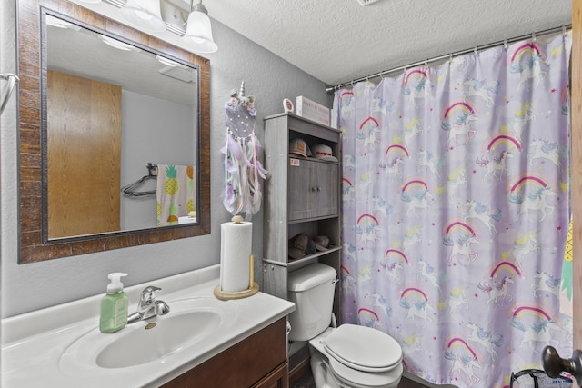 bathroom with curtained shower, toilet, vanity, a textured wall, and a textured ceiling