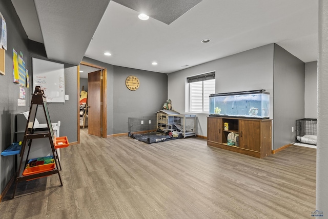 recreation room with recessed lighting, baseboards, and wood finished floors