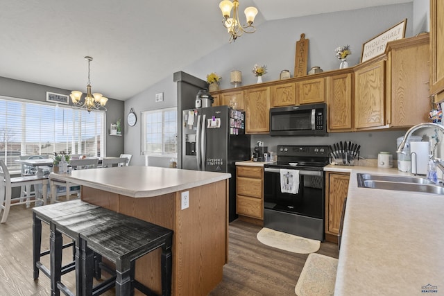 kitchen with black electric range, stainless steel microwave, a sink, an inviting chandelier, and vaulted ceiling