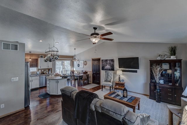 4329 Crooked Oaks Rd, Piedmont, SD 57769 - living room with dark wood-style floors, visible vents, baseboards, vaulted ceiling, and ceiling fan with notable chandelier