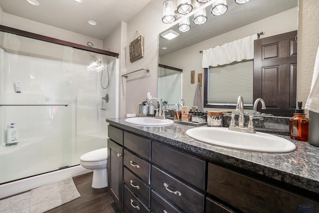 full bath featuring a sink, toilet, wood finished floors, and a shower stall
