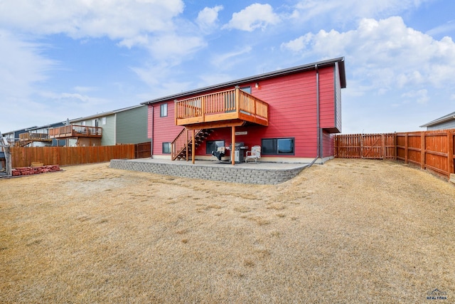 back of property with a deck, a patio area, stairway, and a fenced backyard