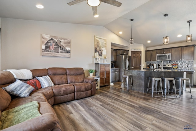 living area featuring a ceiling fan, vaulted ceiling, recessed lighting, and wood finished floors