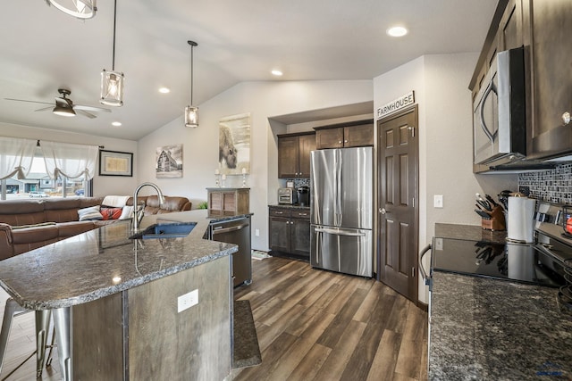 kitchen with dark brown cabinetry, open floor plan, appliances with stainless steel finishes, a ceiling fan, and a sink