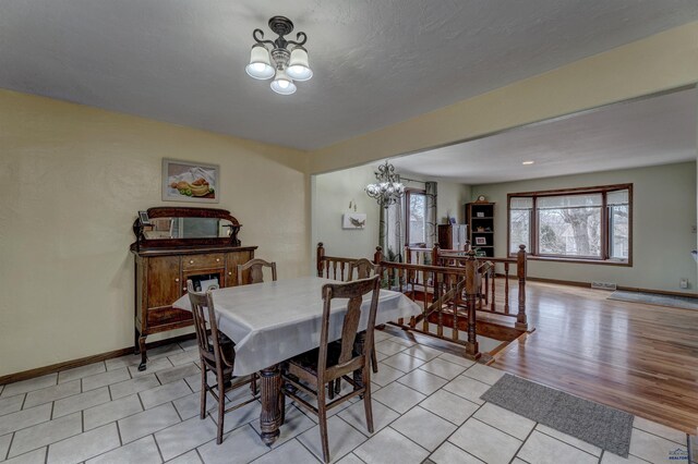 2204 Cruz Dr, Rapid City, SD 57702 - dining area with a notable chandelier, visible vents, baseboards, and light wood-type flooring