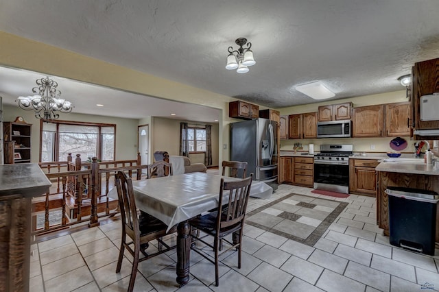 2204 Cruz Dr, Rapid City, SD 57702 - dining space featuring a notable chandelier, recessed lighting, light tile patterned floors, and a textured ceiling